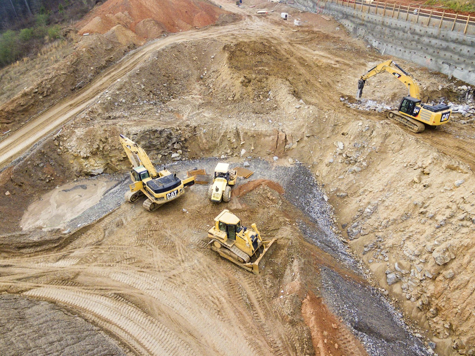 Bagger und Muldenkipper auf einer Erdbaustelle aus der Luft